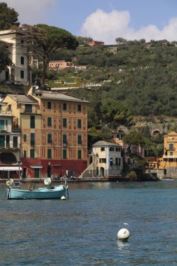 Portofino, İtalya - 5 Nisan 2018: Lüks İtalyan tatiller - güzel Portofino Ligurian kıyısında. Mavi su ve misafir Portofino, köy taç aracılığıyla koy görünümü.