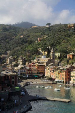 Portofino, İtalya - 5 Nisan 2018: Lüks İtalyan tatiller - güzel Portofino Ligurian kıyısında. Mavi su ve misafir Portofino, köy taç aracılığıyla koy görünümü.