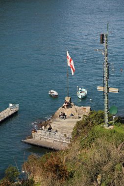 Portofino, İtalya - 5 Nisan 2018: Lüks İtalyan tatiller - güzel Portofino Ligurian kıyısında. Mavi su ve misafir Portofino, köy taç aracılığıyla koy görünümü.