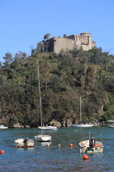 Portofino, İtalya - 5 Nisan 2018: Lüks İtalyan tatiller - güzel Portofino Ligurian kıyısında. Mavi su ve misafir Portofino, köy taç aracılığıyla koy görünümü.