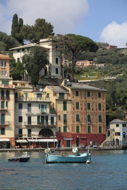 Portofino, İtalya - 5 Nisan 2018: Lüks İtalyan tatiller - güzel Portofino Ligurian kıyısında. Mavi su ve misafir Portofino, köy taç aracılığıyla koy görünümü.