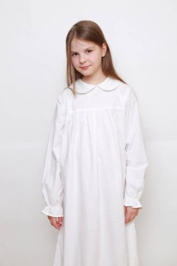 Gecelik giymiş beyaz, güzel bir çocuk.