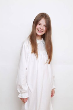 Gecelik giymiş beyaz, güzel bir çocuk.