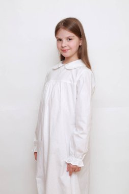 Gecelik giymiş beyaz, güzel bir çocuk.