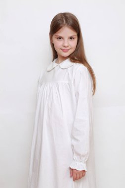 Gecelik giymiş beyaz, güzel bir çocuk.