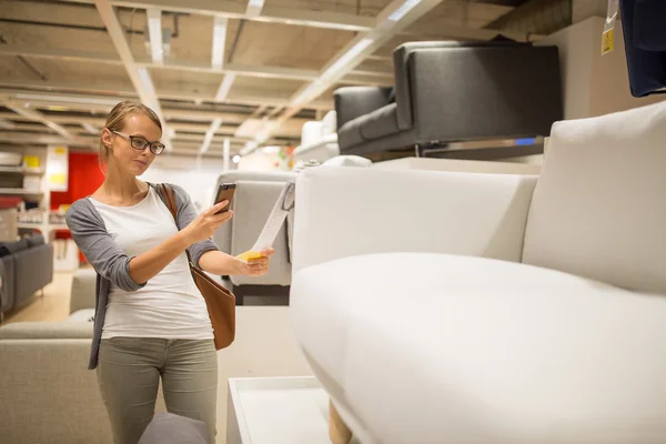 Mujer joven y bonita eligiendo el mobiliario adecuado — Foto de Stock