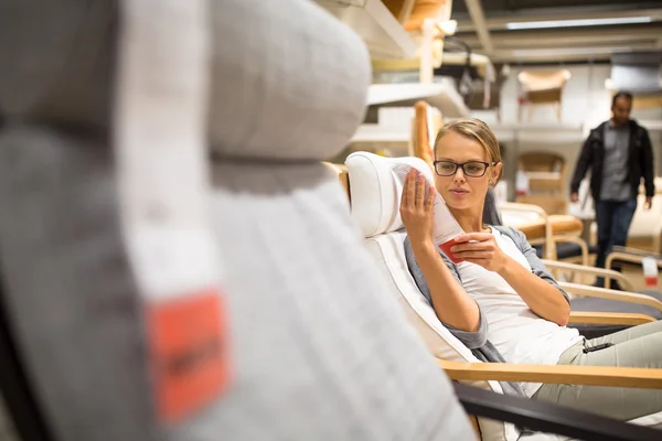 Pretty, young woman choosing the right furniture — Stock Photo, Image