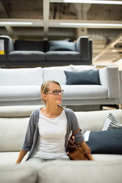 Pretty, young woman choosing the right furniture — Stock Photo, Image