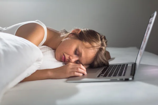 Mujer bastante joven que se queda dormida mientras trabaja en su computadora portátil — Foto de Stock