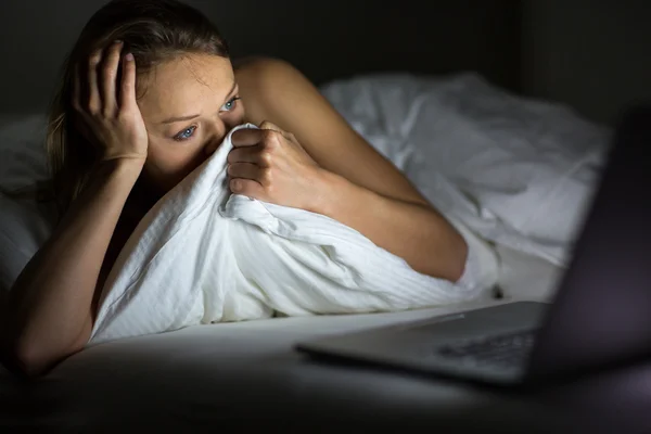 Mujer bastante joven viendo algo horrible / triste en su computadora portátil — Foto de Stock