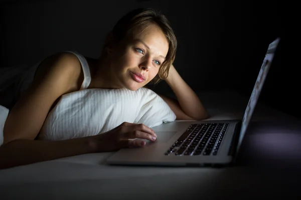Όμορφη, νεαρή γυναίκα χρησιμοποιώντας το φορητό υπολογιστή στο κρεβάτι — Φωτογραφία Αρχείου