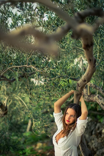 Приваблива, молода брюнетка на пляжі, серед оливкових дерев — стокове фото