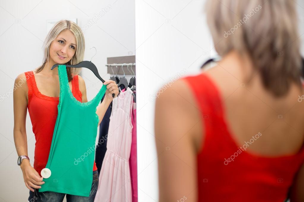 Young woman shopping in a fashion store - Trying on the garments