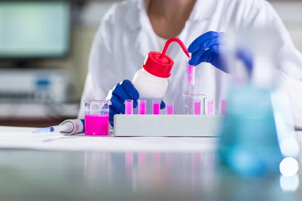 Händerna på en kvinnlig forskare som bedriver forskning i kemi labb — Stockfoto