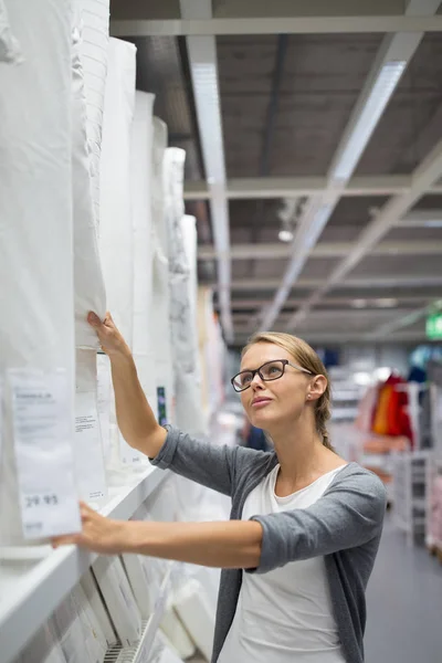 Mujer joven y bonita eligiendo el mobiliario adecuado para su apartamento — Foto de Stock