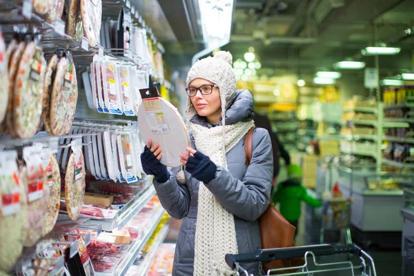 Красива молода жінка купує в продуктовому магазині / супермаркеті — стокове фото