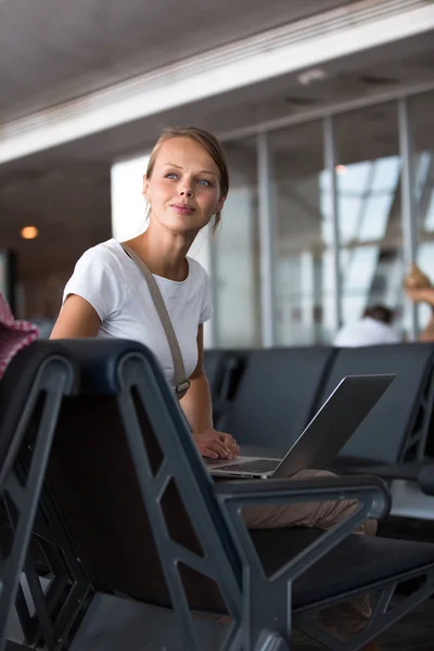 Mujer joven y bonita esperando en un área de puerta de un aeropuerto moderno — Foto de Stock