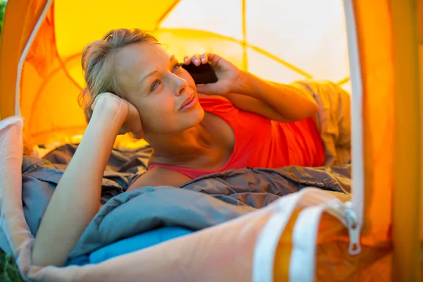Bonita, jovem acampar ao ar livre, deitado na tenda — Fotografia de Stock