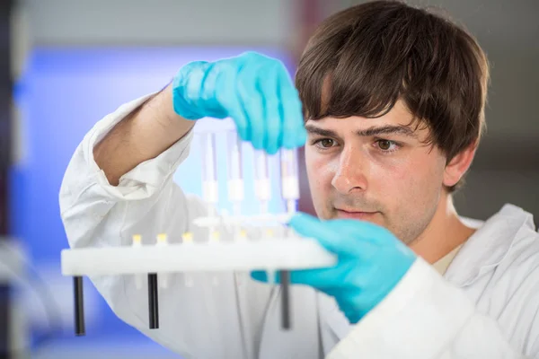 Jovem pesquisador do sexo masculino que realiza pesquisa científica em laboratório — Fotografia de Stock