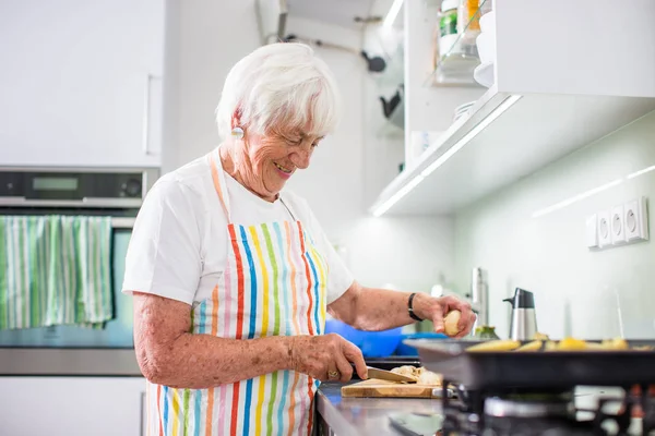 Пожилая женщина готовит — стоковое фото