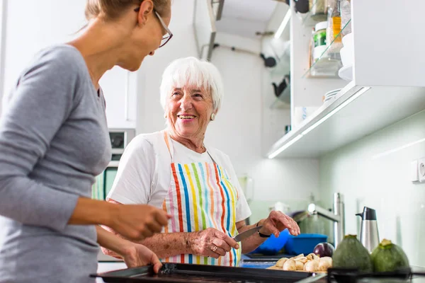 Woman with grandmother cooking — Stock Photo, Image