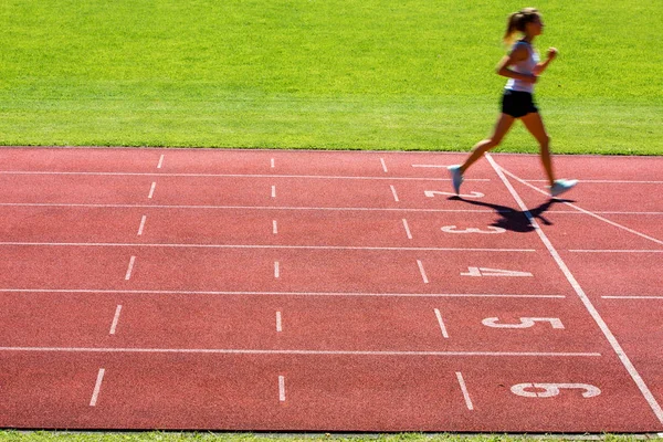 Runner on a running track finishing a race first — Stock Photo, Image