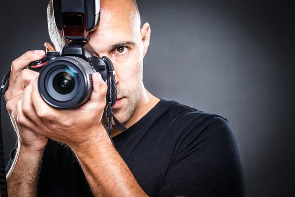 Jovem, fotógrafo masculino profissional em seu estúdio durante uma sessão de fotos — Fotografia de Stock