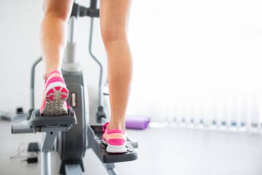 Genç kadının Step/koşu bandı, closeup kaslı bacaklarına