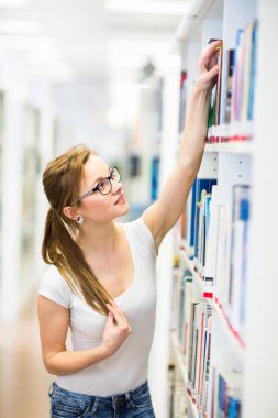 Seyir için bir kitap güzel, kadın üniversite öğrencisi bir Kitaplığı ' nda 