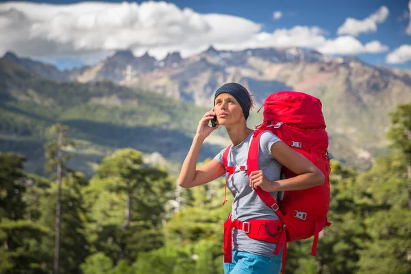 Жіночий пішохід у високих горах дзвонить зі своїм мобільним телефоном — стокове фото