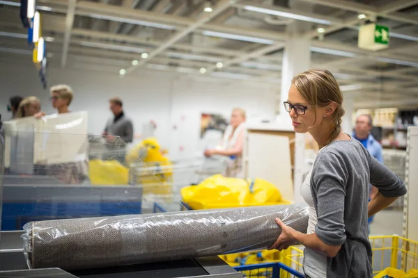 Hübsche, junge Frau bei der Auswahl der richtigen Möbel für ihre Wohnung — Stockfoto