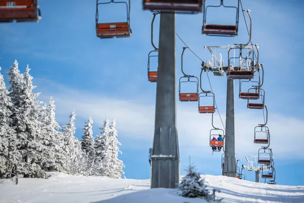 Ski lift with skiers being carried up the hill on a lovely, sunn — Stock Photo, Image