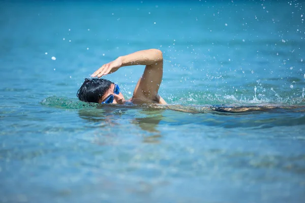 Ung man simmar det främsta crawl i havet (simmare, triathlon) — Stockfoto