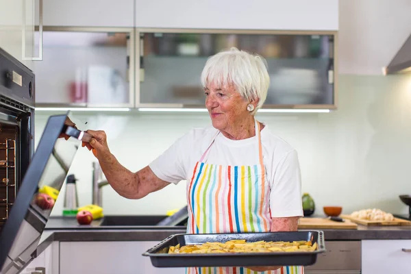 Seniorin kocht in der Küche — Stockfoto