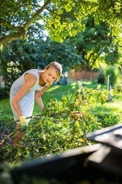 Pretty, young woman gardening in her garden — Stock Photo, Image