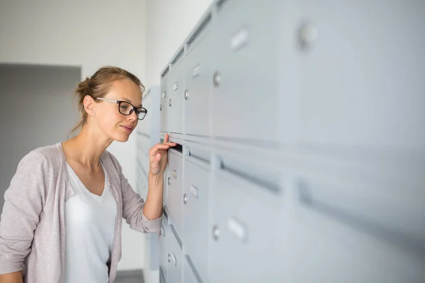 Vacker, ung kvinna kontrollera hennes postlåda för nya bokstäver — Stockfoto