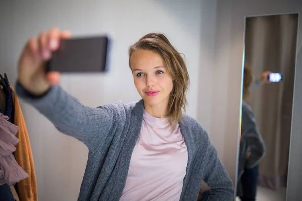 Jonge vrouw winkelen in een mode winkel, proberen op sommige kleding — Stockfoto