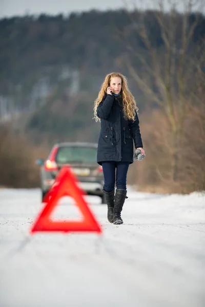 Ung kvinna att inrätta en varningstriangel och efterlyser hjälp — Stockfoto
