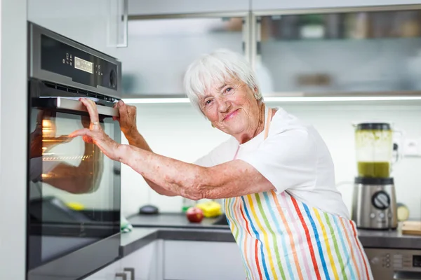 Mulher idosa cozinhar na cozinha - comer e cozinhar saudável — Fotografia de Stock