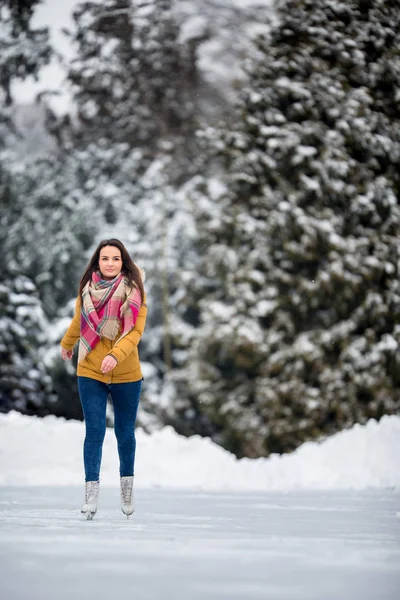 Junge Frau beim Eislaufen im Freien auf einem Teich — Stockfoto