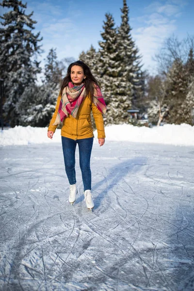 Νεαρή γυναίκα πάγου πατινάζ σε εξωτερικούς χώρους σε μια λιμνούλα ένα πάγωμα χειμώνα — Φωτογραφία Αρχείου