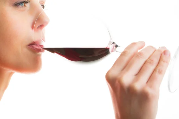 Elegante joven con un vestido rojo, tomando una copa de vino tinto — Foto de Stock