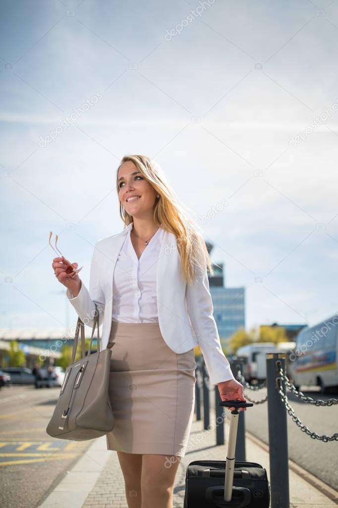 Young female passenger at the airport, walking to he departure t