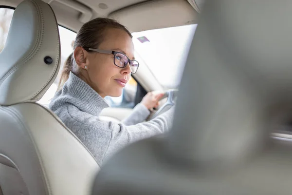 Bonita, jovem mulher dirigindo seu carro novo — Fotografia de Stock