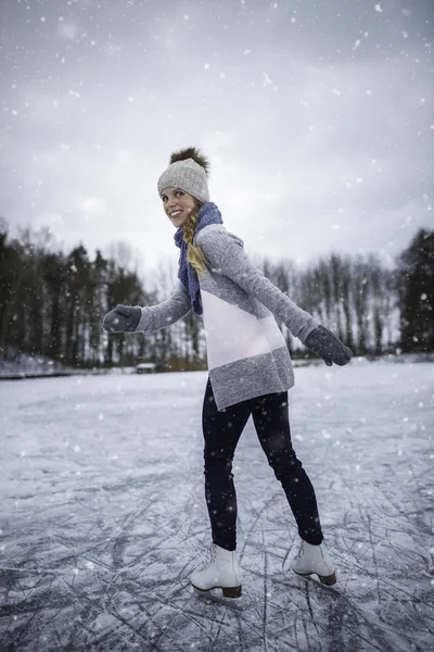 Giovane donna pattinaggio su ghiaccio all'aperto su uno stagno in un inverno gelido — Foto Stock