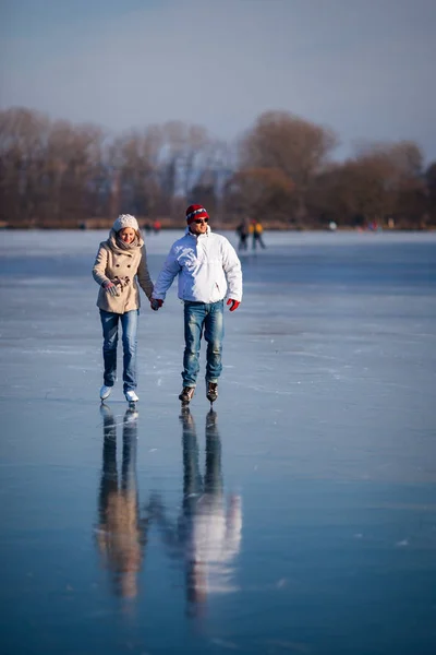 Couple patinage sur glace à l'extérieur sur un étang — Photo