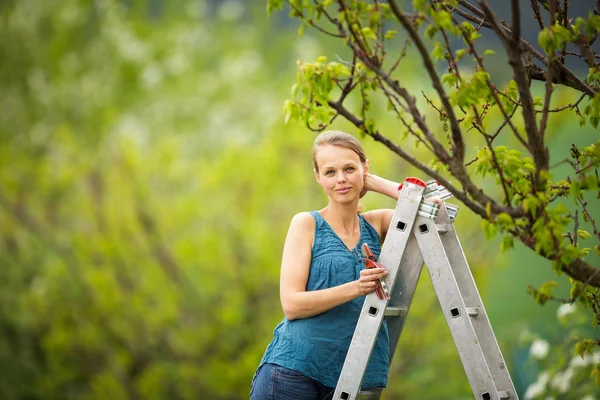 Bella, giovane donna giardinaggio nel suo frutteto / giardino — Foto Stock