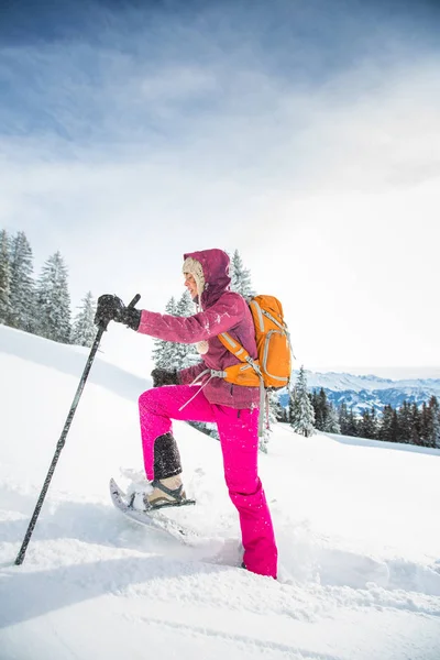 Досить, молода жінка сніжить у високих горах, насолоджуючись шпилем — стокове фото