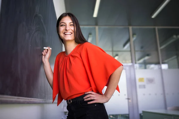 Bonito, jovem estudante universitário escrevendo no quadro / blackboa — Fotografia de Stock