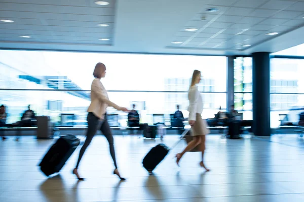 Gente corriendo por un moderno corredor aeroportuario — Foto de Stock